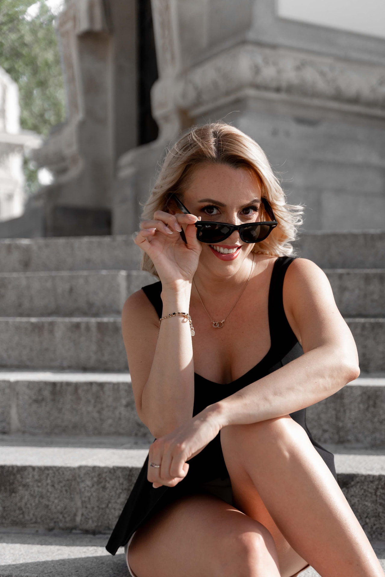 Creator in sunglasses sitting on city steps
